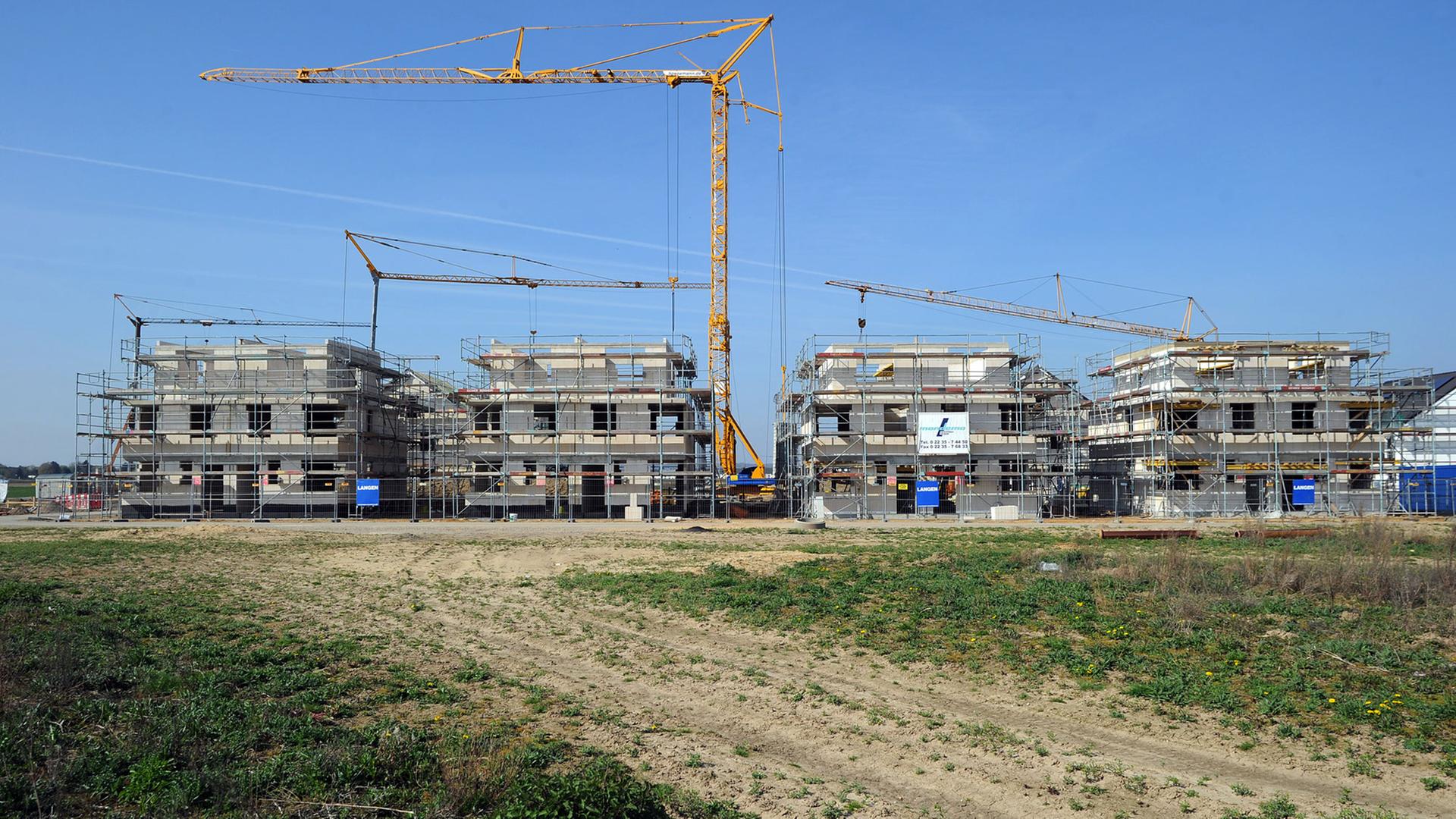 Ein Kran überragt im Neubaugebiet Widdersdorf-Süd in Köln (Nordrhein-Westfalen) im Bau befindliche Häuser. Auf etwa 1200 Baugrundstücken entstehen hier Ein- und Mehrfamilienhäuser. Ein Kran überragt im Neubaugebiet Widdersdorf-Süd in Köln (Nordrhein-Westfalen) im Bau befindliche Häuser. Auf etwa 1200 Baugrundstücken entstehen hier Ein- und Mehrfamilienhäuser.