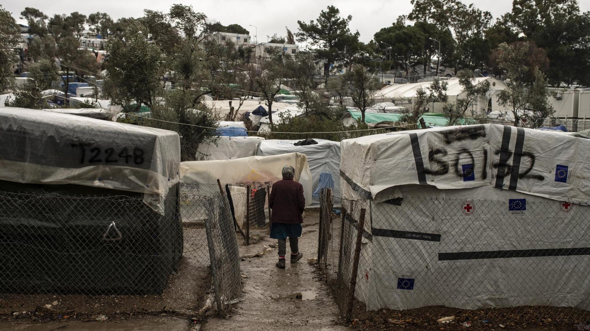 Eine Migrantin steht im Regen, im Moria Lager auf Lesbos Eine Migrantin steht im Regen, im Moria Lager auf Lesbos