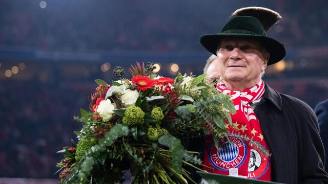 Uli Hoeneß, Ehrenpräsident vom FC Bayern, 2019 mit Blumenstrauß bei einer Ehrung im Stadion