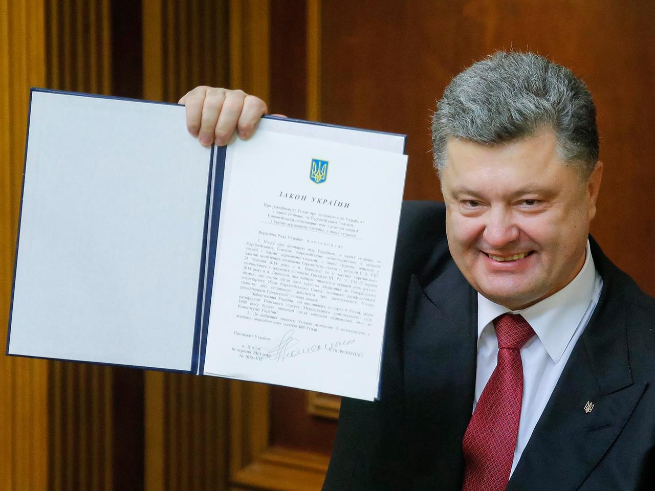Petro Poroschenko hält das unterzeichnete EU-Partnerschaftsabkommens hoch. Petro Poroschenko hält das unterzeichnete EU-Partnerschaftsabkommens hoch.