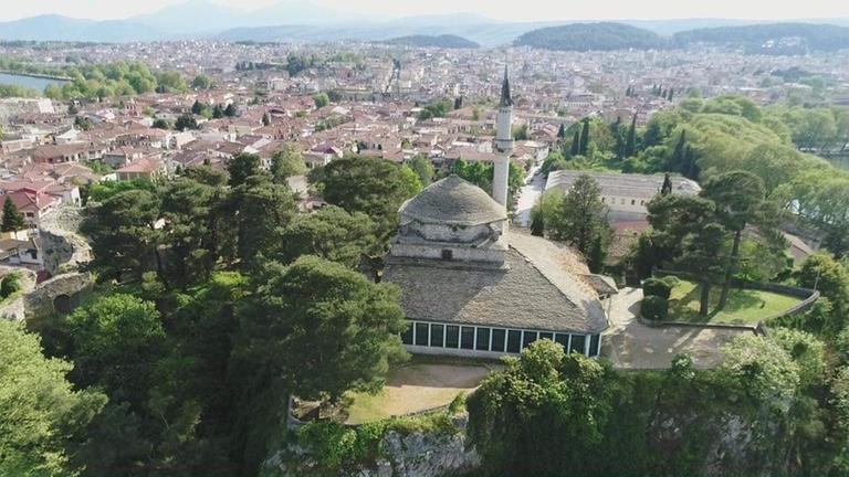 Eine Stadt im Grünen, im Vordergrund eine Moschee mit Minarett. Eine Stadt im Grünen, im Vordergrund eine Moschee mit Minarett.