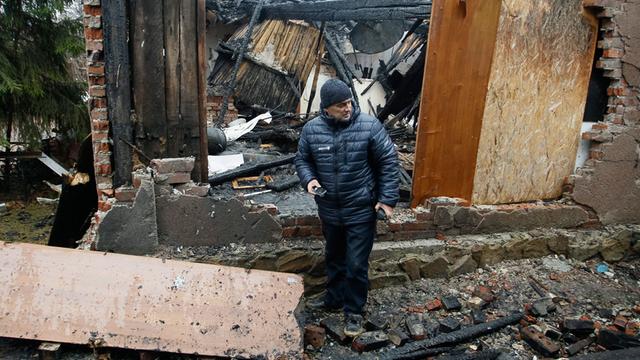 Ein Mann steht in den Ruinen seines Hauses, das während Kämpfen in der Nähe des Flughafens von Donezk zerstört wurde.