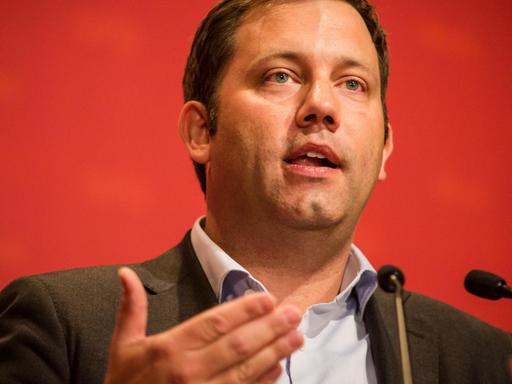 SPD-Generalsekretär Lars Klingbeil sprechend an einem Mikrophon vor rotem Hintergrund