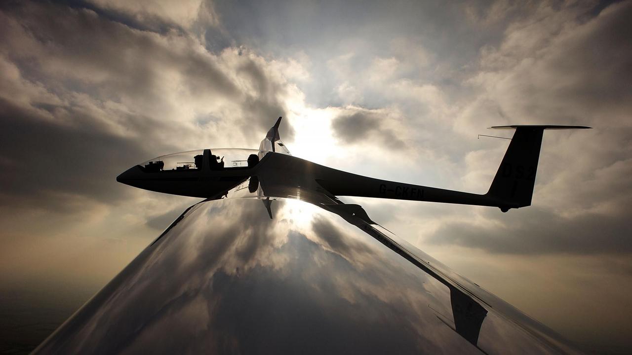 Ein Segelflieger in der Luft, vor Wolken und Sonne. Ein Segelflieger in der Luft, vor Wolken und Sonne.