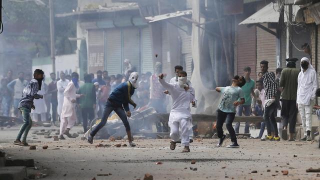 Jugendliche werfen Steine auf ein indisches Polizeiauto während der Unruhen in Srinagar, der Sommerhauptstadt des indischen Teils Kaschmirs.