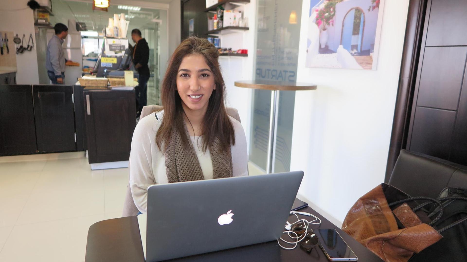 Die junge Start-up-Unternehmerin Laila Akel sitzt vor ihrem Laptop in einem Café. Die junge Start-up-Unternehmerin Laila Akel sitzt vor ihrem Laptop in einem Café.