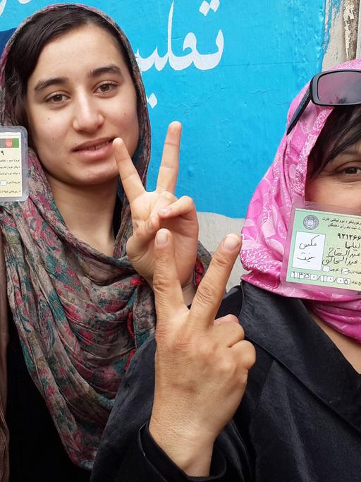 Zwei afghanischen Frauen zeigen ihre Wahlkarten