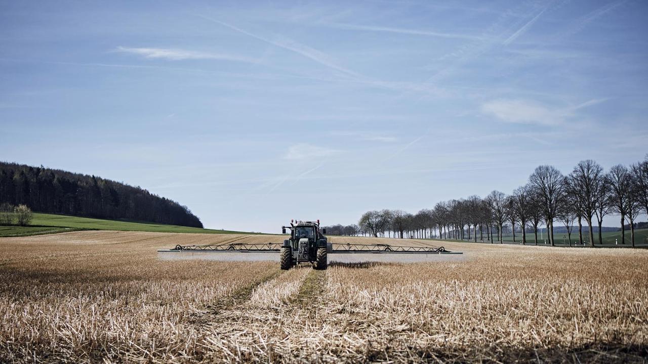 Ein Traktor bringt Glyphosat auf einem Feld in Niedersachsen aus Ein Traktor bringt Glyphosat auf einem Feld in Niedersachsen aus