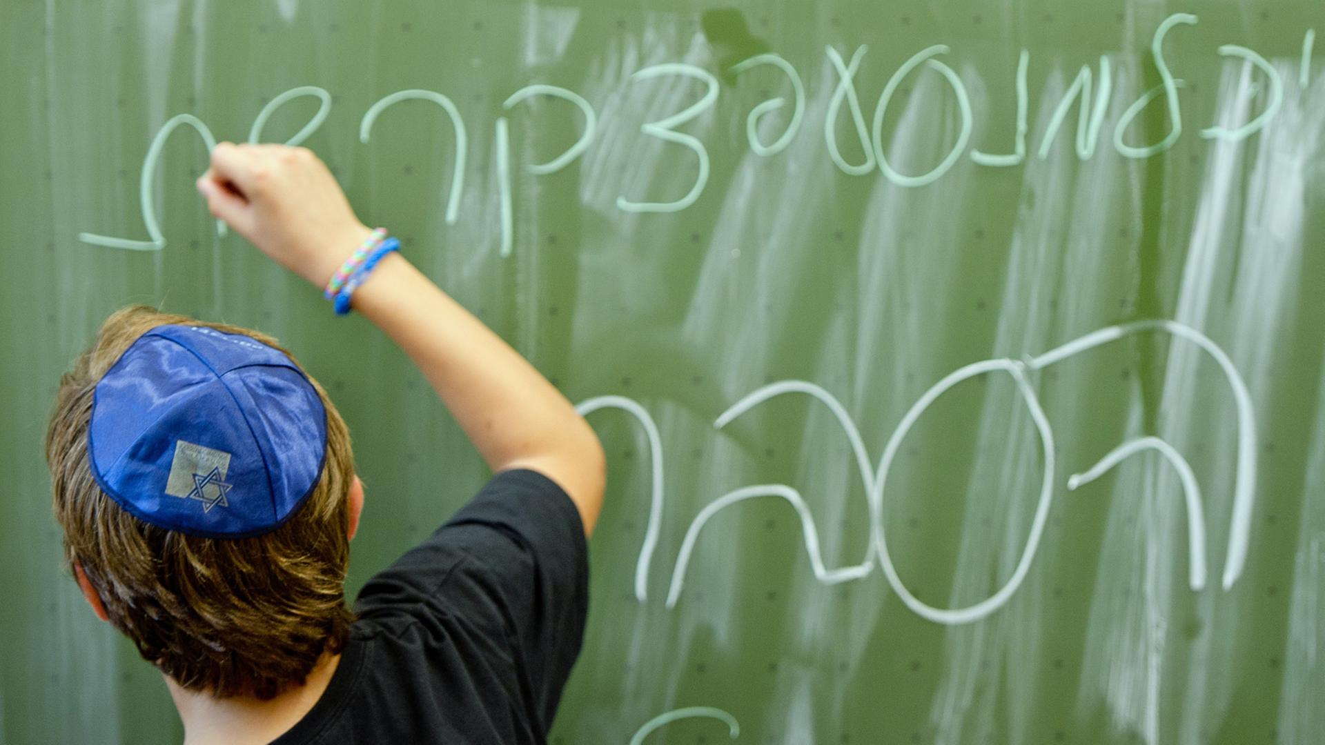 Ein Schüler der Talmud Tora Schule in Hamburg schreibt das Alphabet auf hebräisch an die Tafel. Unten steht das Wort "lernen". Ein Schüler der Talmud Tora Schule in Hamburg schreibt das Alphabet auf hebräisch an die Tafel. Unten steht das Wort "lernen".