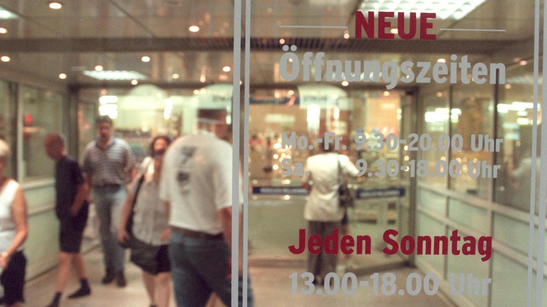 Eingangstür zu einem Kaufhaus mit der Aufschrrift "Neue Öffnungszeiten - Jeden Sonntag 13.00 - 18.00 Uhr" Eingangstür zu einem Kaufhaus mit der Aufschrrift "Neue Öffnungszeiten - Jeden Sonntag 13.00 - 18.00 Uhr"