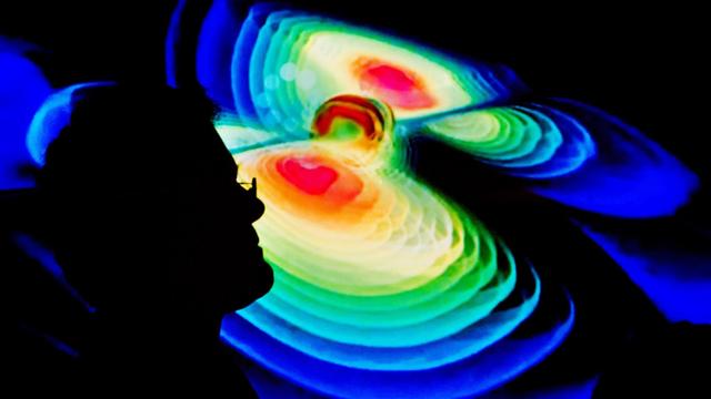 Der Schattenriss eines Wissenschaftlers ist am 11.02.2016 auf einer Visualisierung von Gravitationswellen während einer Pressekonferenz vom Max-Planck-Institut für Gravitationsphysik (Albert Einstein Institut) in der Leibniz Universität in Hannover (Niedersachsen) zu sehen.