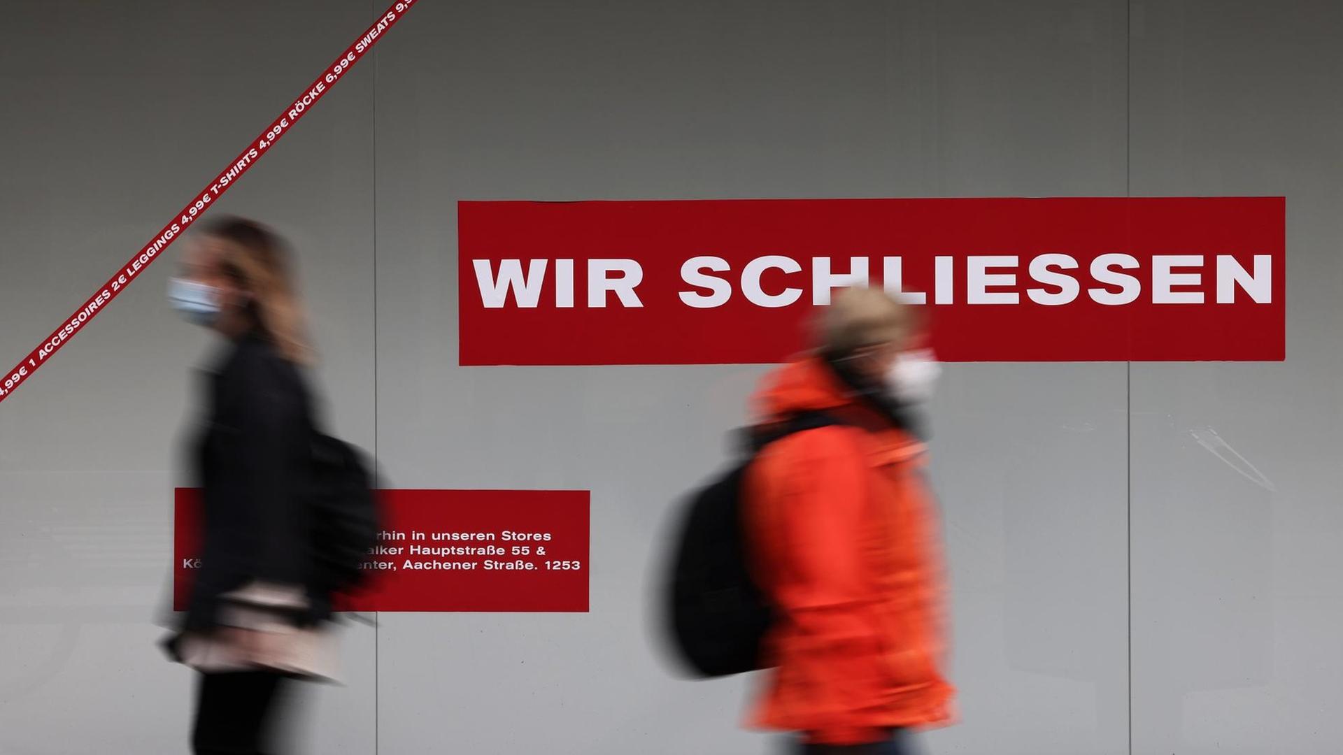 Passanten gehen in der Innenstadt an einem geschlossen Ladenlokal vorbei. Die Inzidenz bei den Corona-Neuinfektionen in Nordrhein-Westfalen bewegt sich um die Marke von 100.