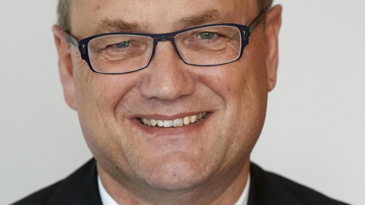 Portrait eines lächelnden, bebrillten Mannes mit Anzug und Krawatte. Portrait eines lächelnden, bebrillten Mannes mit Anzug und Krawatte.