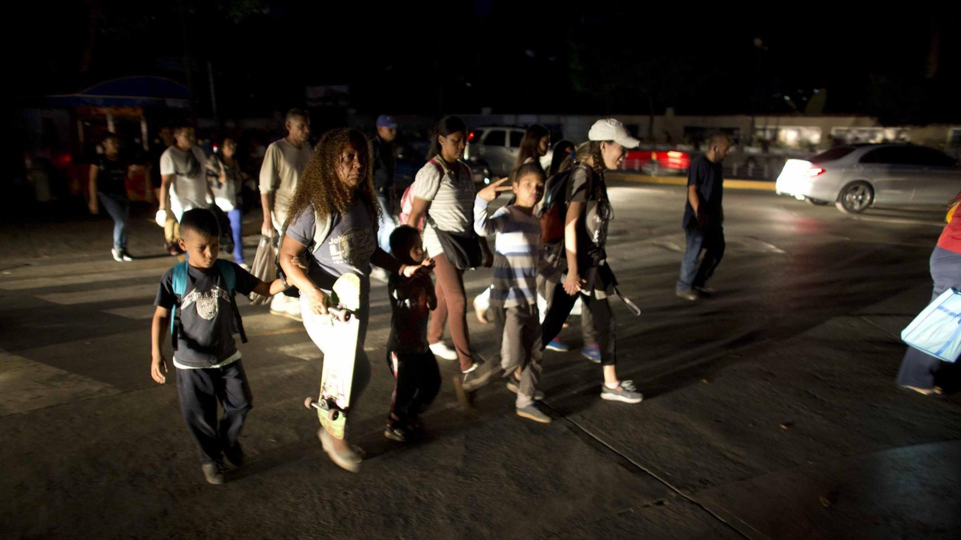 Nach dem landesweiten Stromausfall: Menschen laufen durch die dunklen Straßen von Caracas. Nach dem landesweiten Stromausfall: Menschen laufen durch die dunklen Straßen von Caracas.