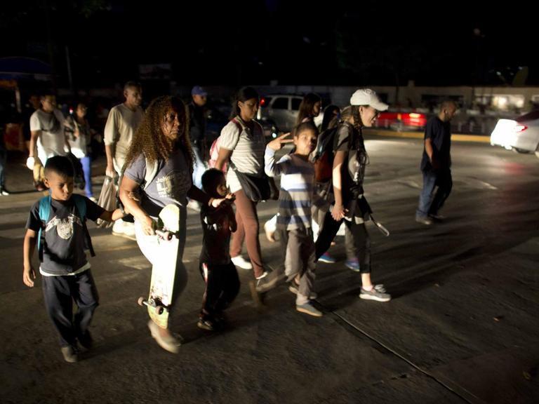 Nach dem landesweiten Stromausfall: Menschen laufen durch die dunklen Straßen von Caracas.