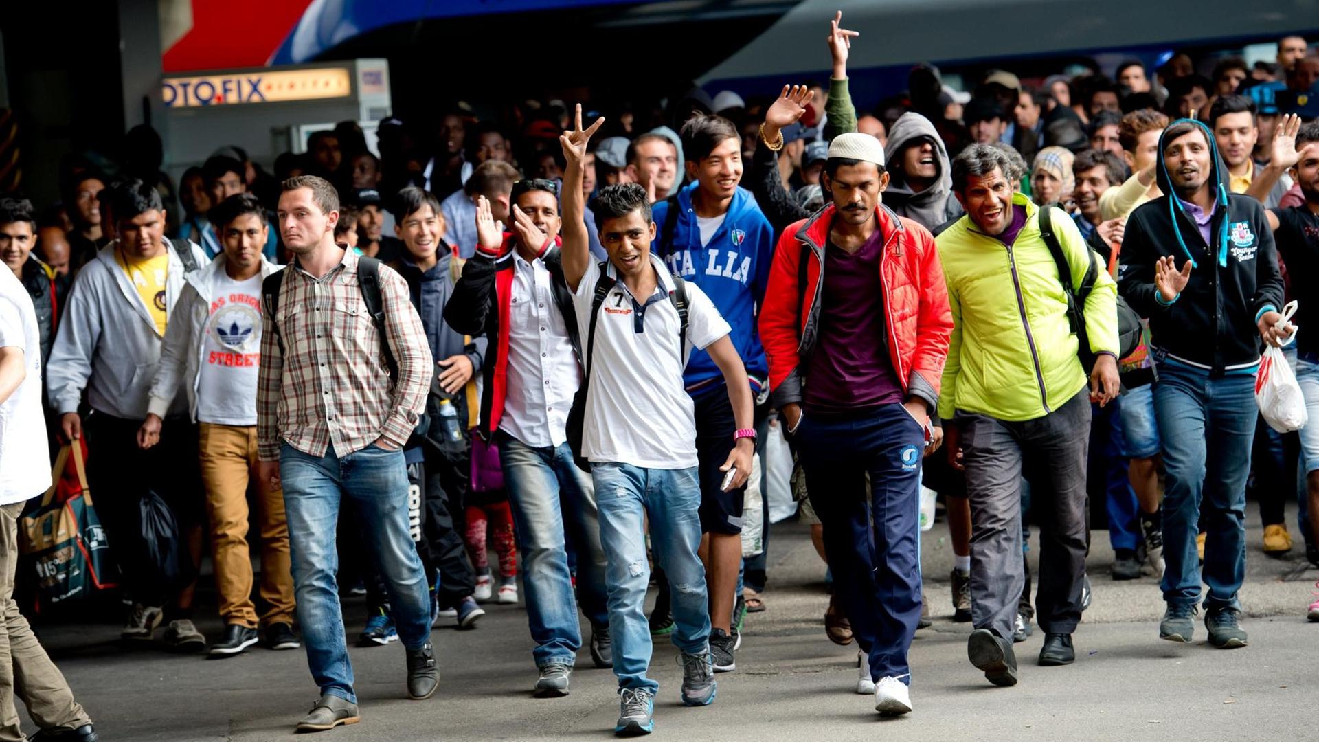 Flüchtlinge jubeln am Hauptbahnhof in München nach ihrer Ankunft Flüchtlinge jubeln am Hauptbahnhof in München nach ihrer Ankunft