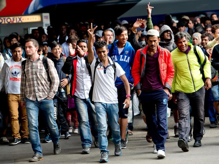 Flüchtlinge jubeln am Hauptbahnhof in München nach ihrer Ankunft