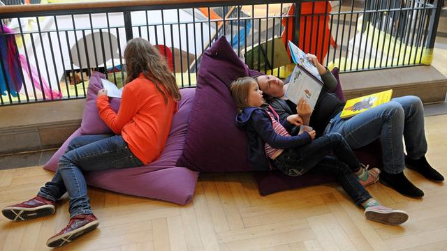 Besucher lesen am 03.11.2013 auf der Kinder- und Jugendbuchmesse (KIBUM) in Oldenburg (Niedersachsen) neue Kinder- und Jugendbücher.