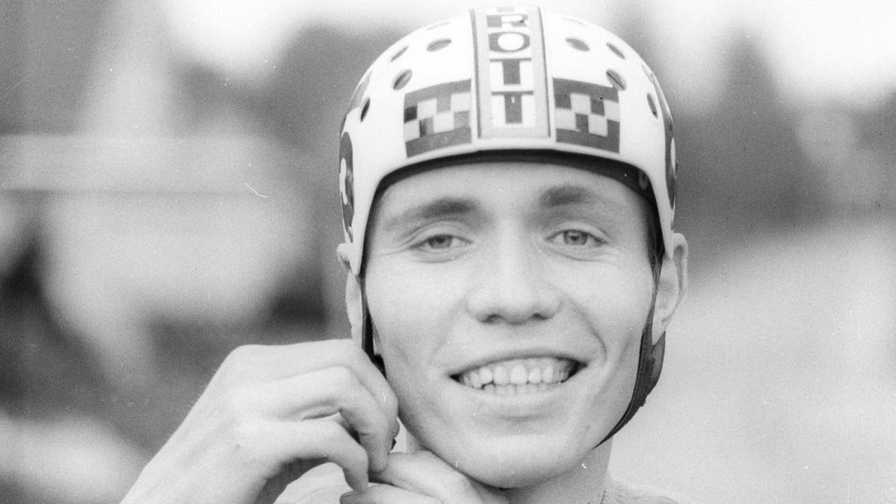Schwarz-Weiß-Porträt des Amateur-Radrennfahrers Wilfried Trott, auf dem dieser den von seinem Vater entwickelten Fahrradhelm trägt. Schwarz-Weiß-Porträt des Amateur-Radrennfahrers Wilfried Trott, auf dem dieser den von seinem Vater entwickelten Fahrradhelm trägt.