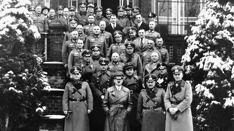 Das Foto aus dem Jahr 1934 zeigt Reichskanzler Adolf Hitler (unten M) und Wernher von Braun (vorletzte Reihe oben M) vor dem Offizierscasino des Versuchsschießplatzes Kummersdorf.