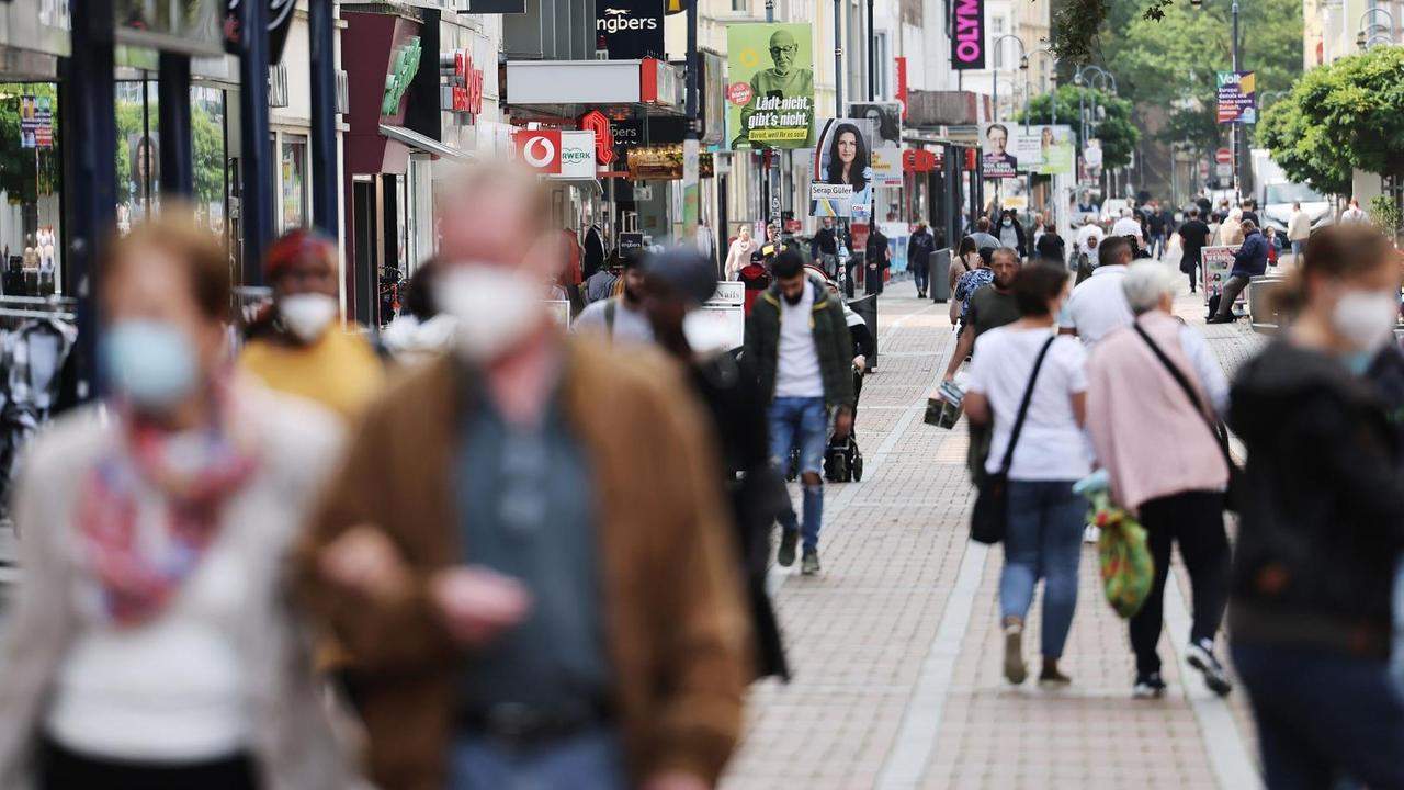 Menschen gehen durch die Fußgängerzone in Leverkusen Menschen gehen durch die Fußgängerzone in Leverkusen