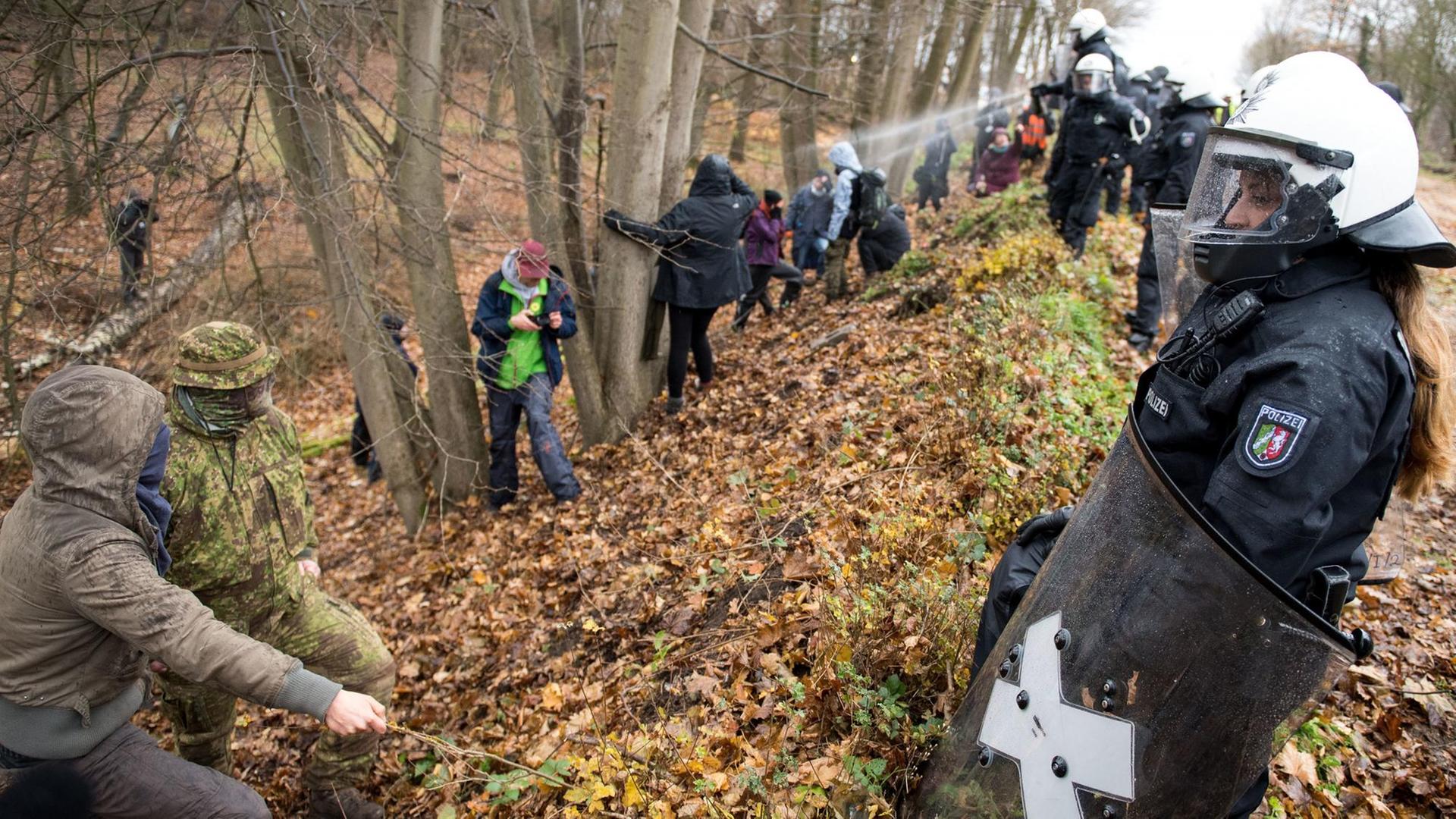 Polizisten und Demonstranten stehen sich am 27.11.2017 im Hambacher Wald in Kerpen (Nordrhein-Westfalen) gegenüber. Polizisten und Demonstranten stehen sich am 27.11.2017 im Hambacher Wald in Kerpen (Nordrhein-Westfalen) gegenüber.