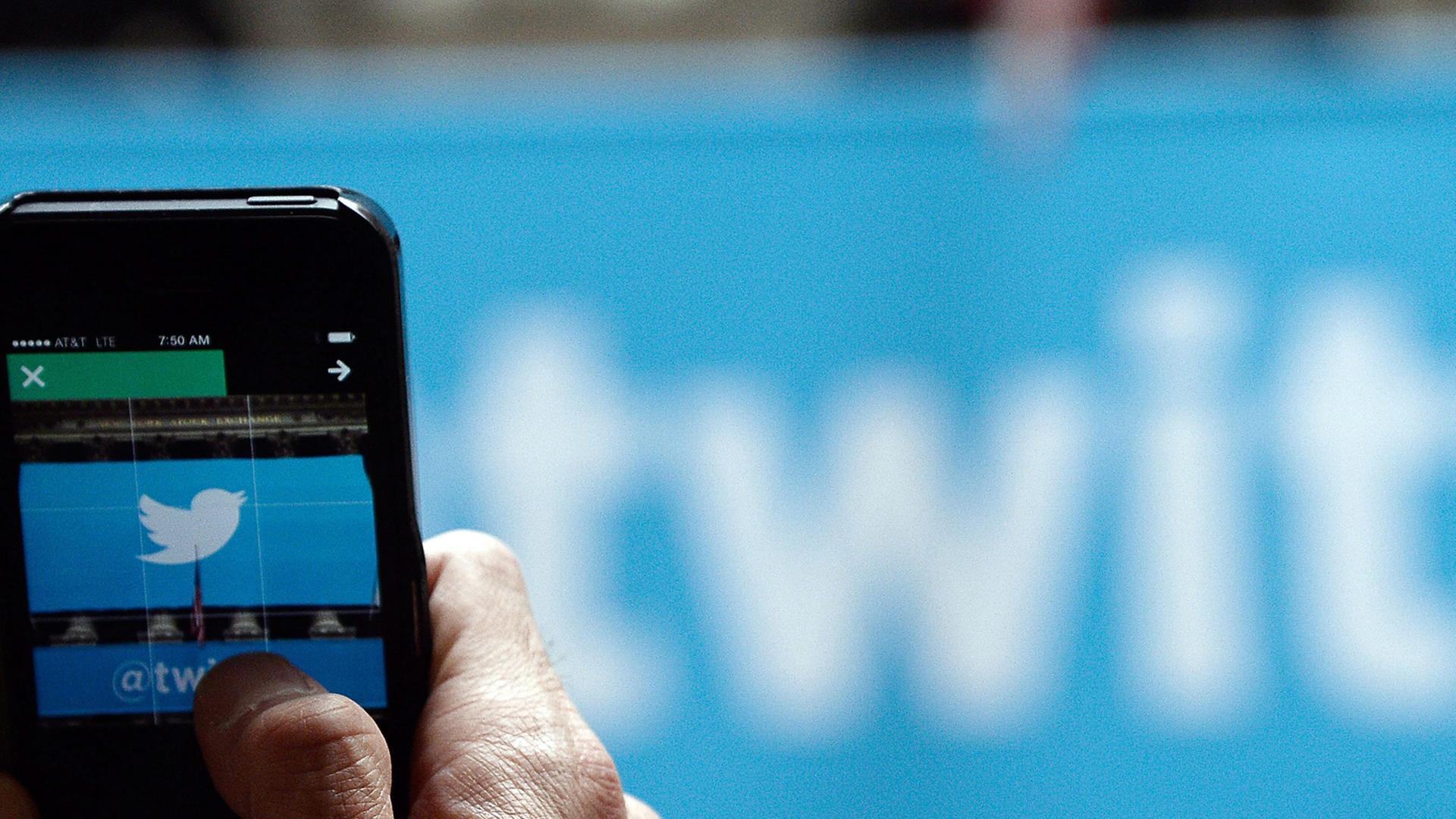 Ein Mann öffnet auf seinem Smartphone seinen Twitter-Account. Ein Mann öffnet auf seinem Smartphone seinen Twitter-Account.