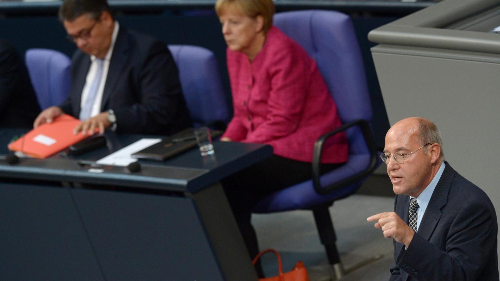 Gregor Gysi von der Partei "Die Linke" spricht im September 2014 im Bundestag in Berlin - im Hintergrund: Kanzlerin Merkel von der CDU. Gregor Gysi von der Partei "Die Linke" spricht im September 2014 im Bundestag in Berlin - im Hintergrund: Kanzlerin Merkel von der CDU.