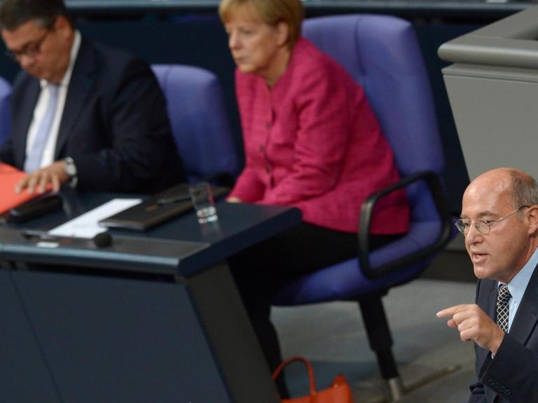 Gregor Gysi von der Partei "Die Linke" spricht im September 2014 im Bundestag in Berlin - im Hintergrund: Kanzlerin Merkel von der CDU.