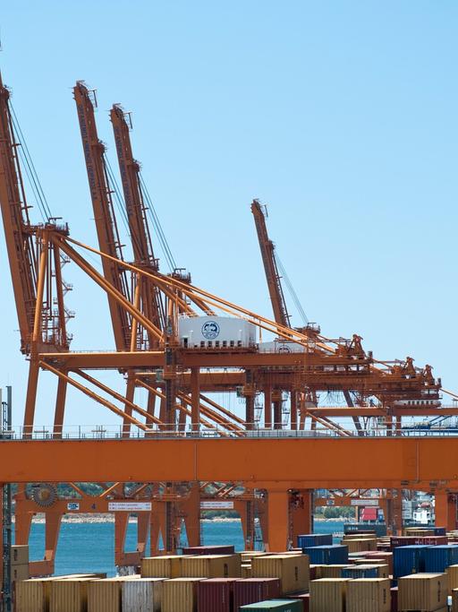 Container und Cosco-Kräne im Hafen von Piräus