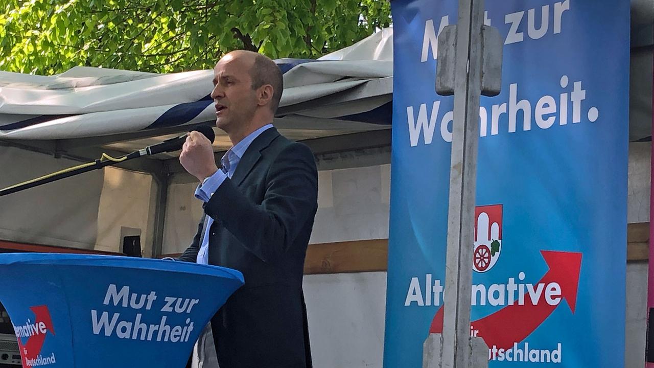 AfD-Kandidat Nicolaus Fest steht im EU-Wahlkampf vor blauen AfD-Plakaten auf einer Bühne.