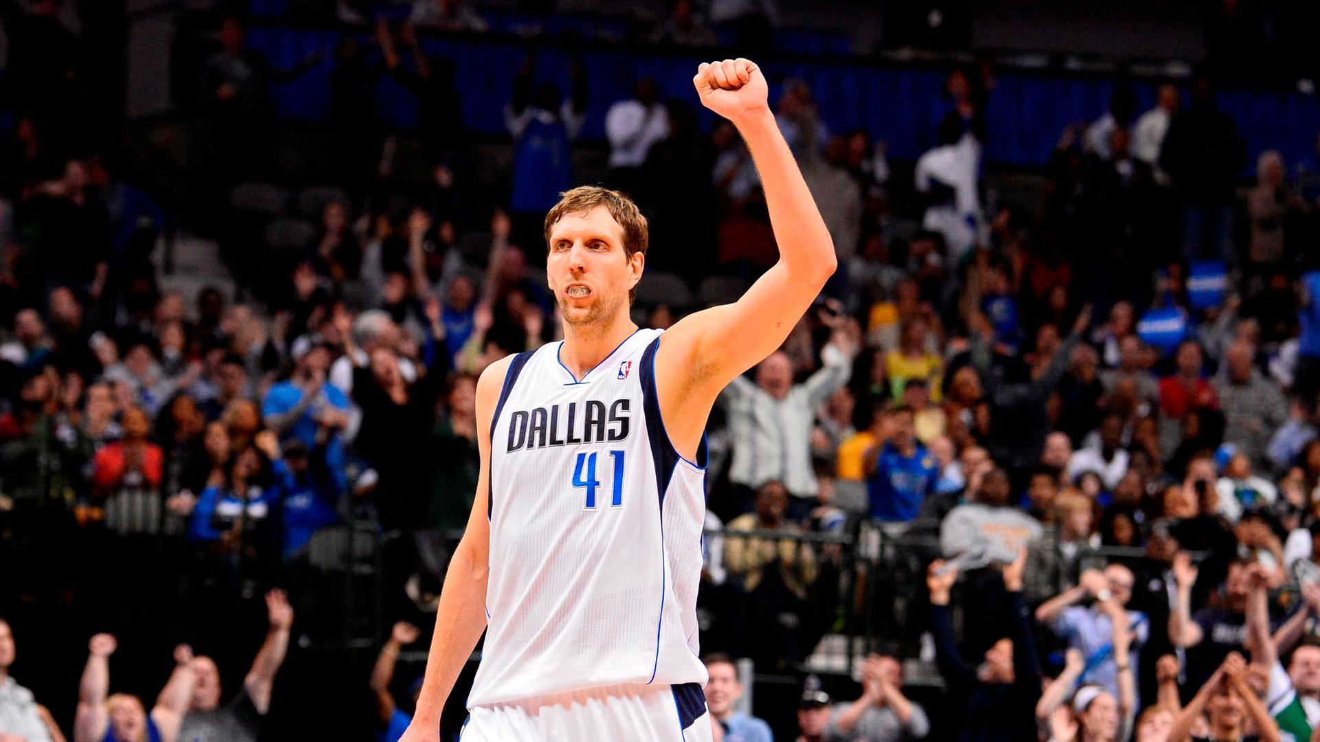 Nowitzki steht in der Sporthalle und reckt die Faust Nowitzki steht in der Sporthalle und reckt die Faust