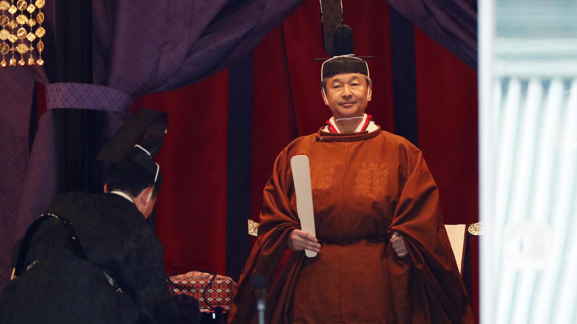 Japans neuer Kaiser in einem orangenen Umhang. Japans neuer Kaiser in einem orangenen Umhang.