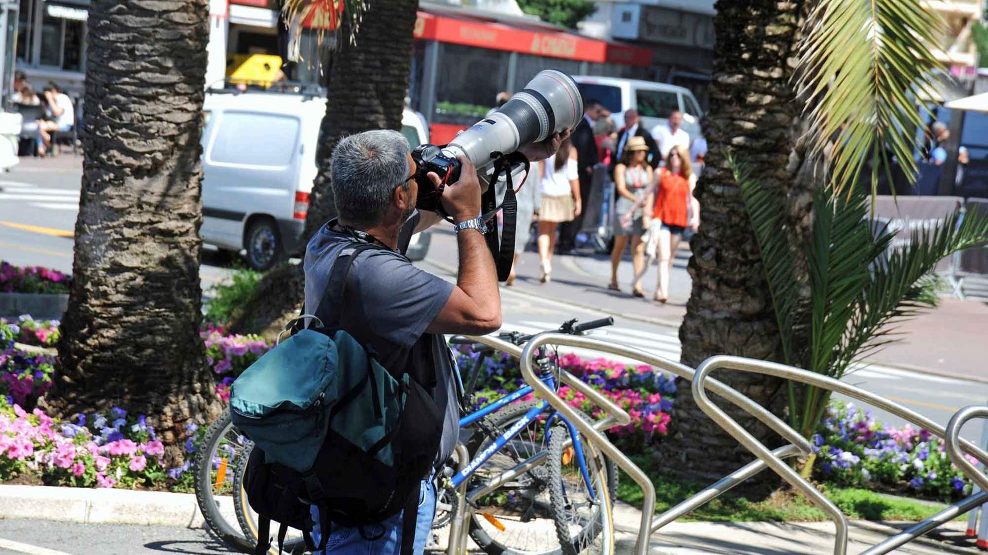 Ein Paparazzo fotografiert ein Starlet in Cannes. Ein Paparazzo fotografiert ein Starlet in Cannes.