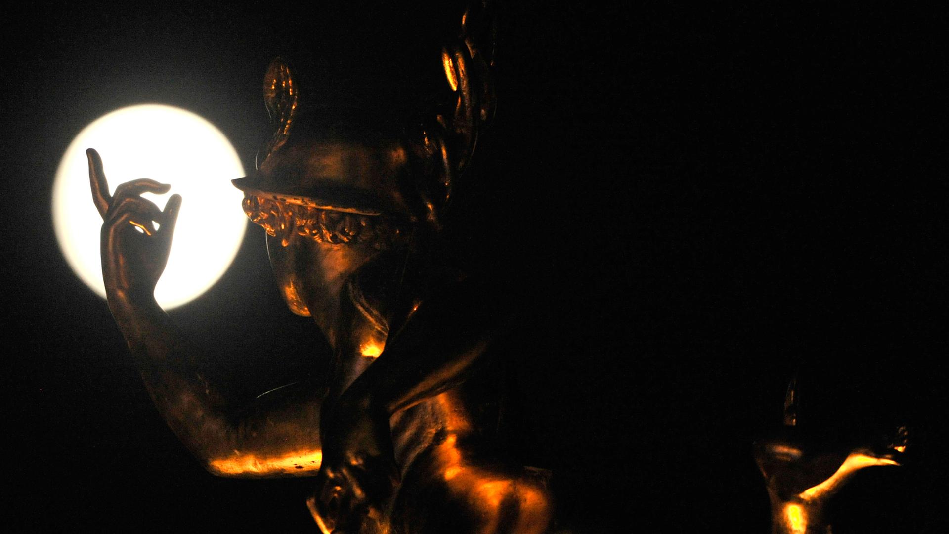 Die Statue des Merkur auf der Alten Kanzlei in Stuttgart scheint nach dem Mond zu greifen. Die Statue des Merkur auf der Alten Kanzlei in Stuttgart scheint nach dem Mond zu greifen.