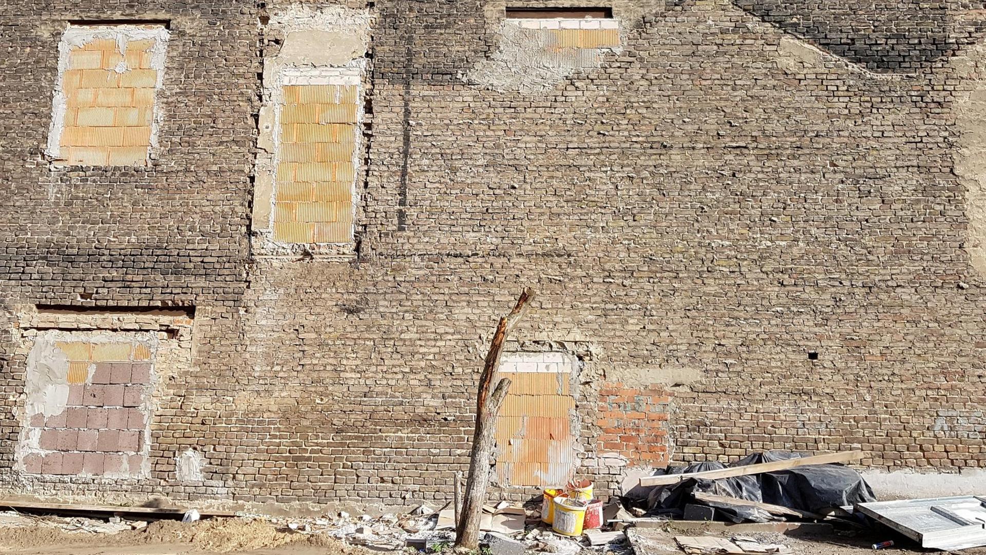 Die Brandmauer eines alten Wohnhause in Berlin-Pankow im Bereich der ehemaligen Mauer, die bei Renovierungsarbeiten freigelegt wurde und Spuren früherer Anbauten zeigt. Die Brandmauer eines alten Wohnhause in Berlin-Pankow im Bereich der ehemaligen Mauer, die bei Renovierungsarbeiten freigelegt wurde und Spuren früherer Anbauten zeigt.