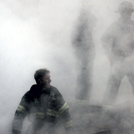 Ein Feuerwehrmann nach dem Einsturz des World Trade Centers zwischen Rauch und Trümmern zu sehen Ein Feuerwehrmann nach dem Einsturz des World Trade Centers zwischen Rauch und Trümmern zu sehen