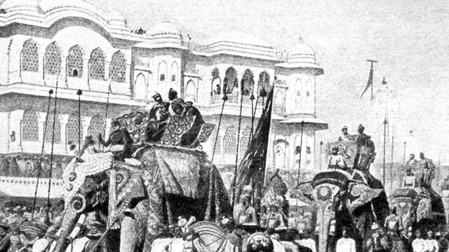 Zu sehen ist ein altes Bild mit einer Parade von Elefanten, auf deren Rücken die königlichen Würdenträger sitzen.