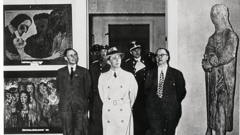 NS-Propagandaminister Joseph Goebbels in  der Ausstellung Entartete Kunst in Berlin, Februar 1938. Links Die Sünderin. | 