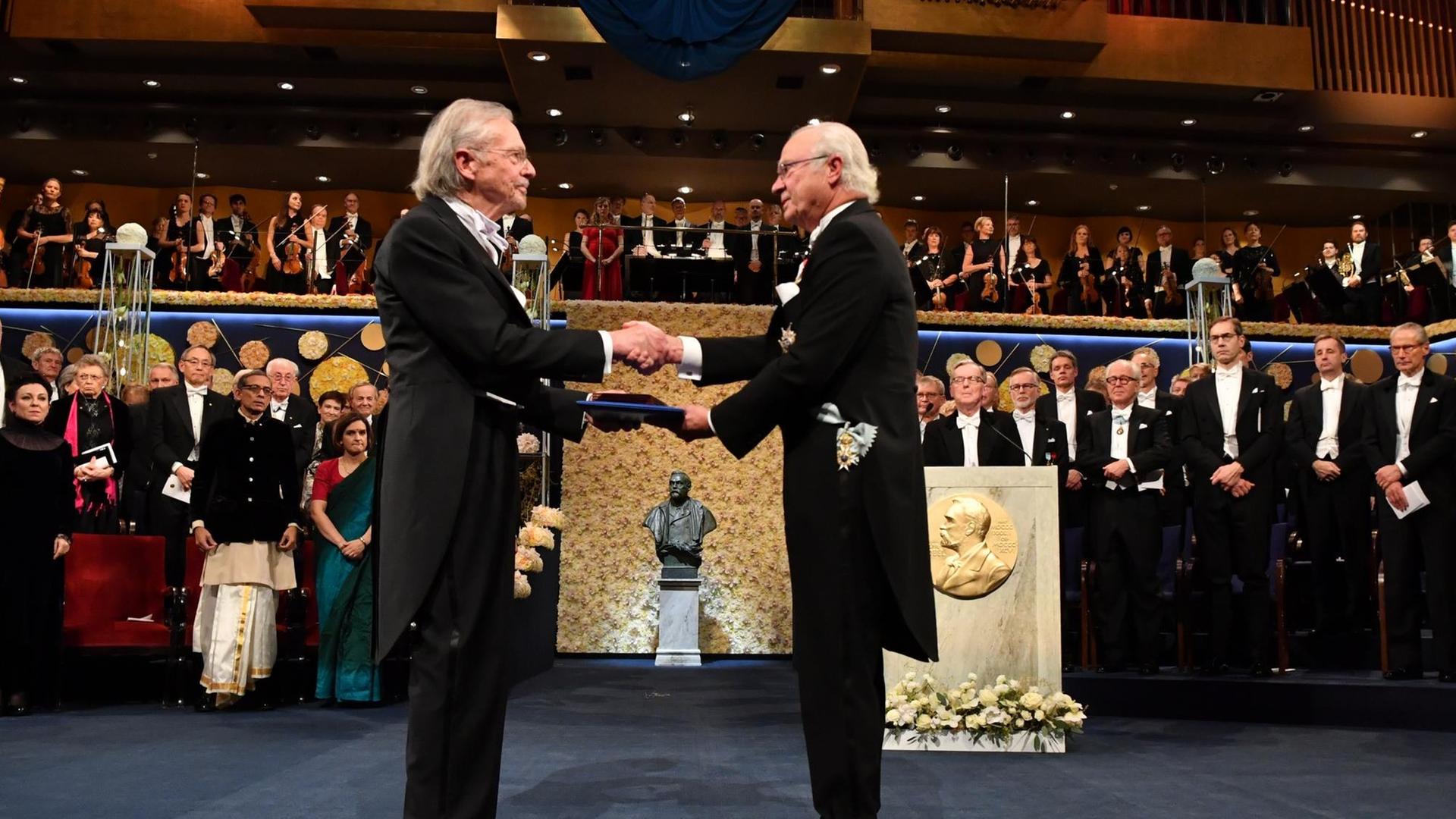 Peter Handke (links) bekommt den Nobelpreis vom schwedischen König Carl Gustaf überreicht.