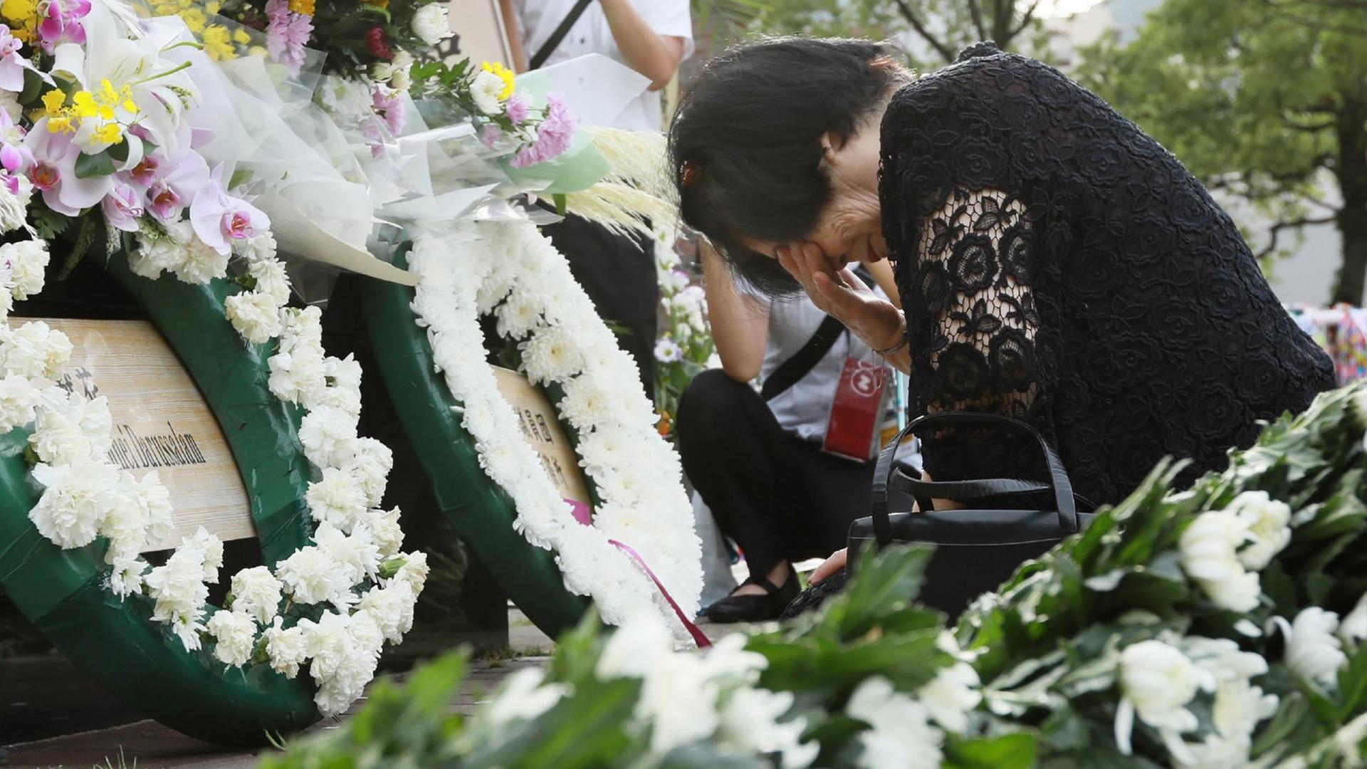 Eine Frau trauert um ihre Schwester, die vor 74 Jahren beim Atombombenabwurf auf Nagasaki getötet wurde. Eine Frau trauert um ihre Schwester, die vor 74 Jahren beim Atombombenabwurf auf Nagasaki getötet wurde.