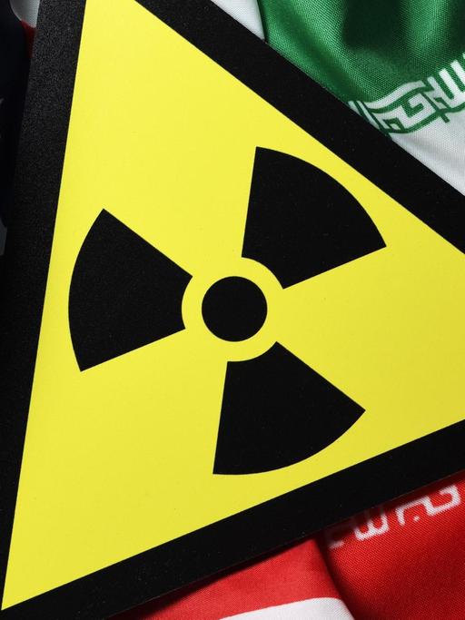 Eine Bildkollage auf der die Fahnen der USA und des Iran sowie ein Radioaktivitätwarnschild zu sehen sind.