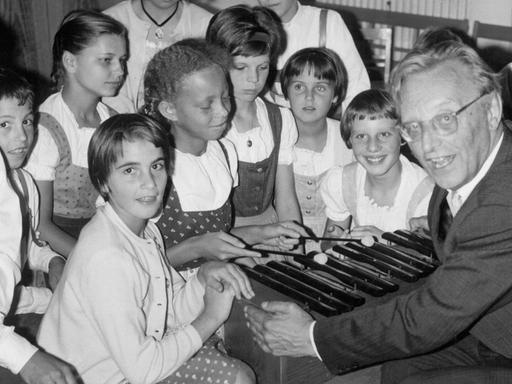 Der deutsche Komponist Carl Orff ("Carmina Burana") zeigt Kindern des SOS-Kinderdorfes in Dießen am Ammersee am 28.9.1964 das Musizieren mit einem Xylophon.