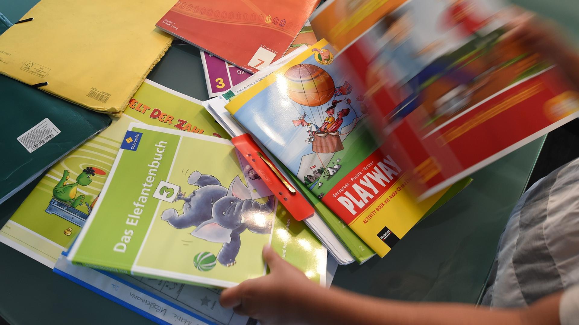 Eine Grundschülerin sortiert ihre Schulbücher Eine Grundschülerin sortiert ihre Schulbücher