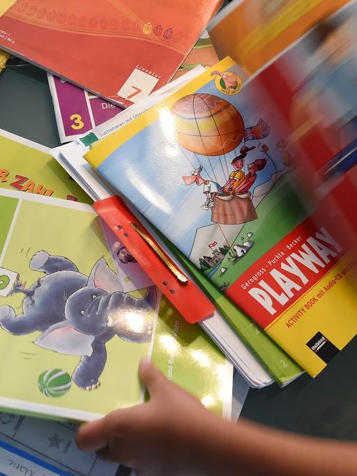 Eine Grundschülerin sortiert ihre Schulbücher