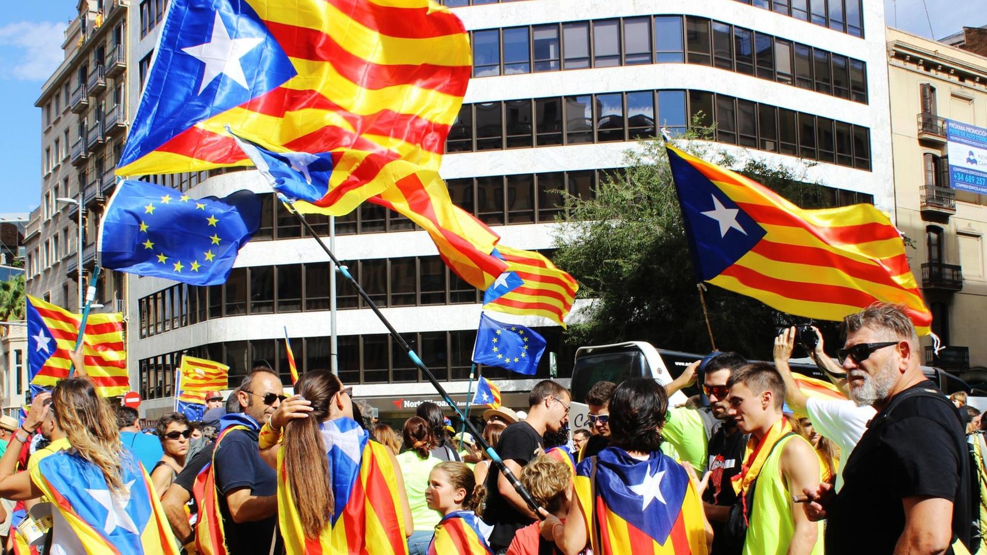 I partecipanti a una manifestazione l'11 settembre 2017 sventolano bandiere catalane in una strada di Barcellona.