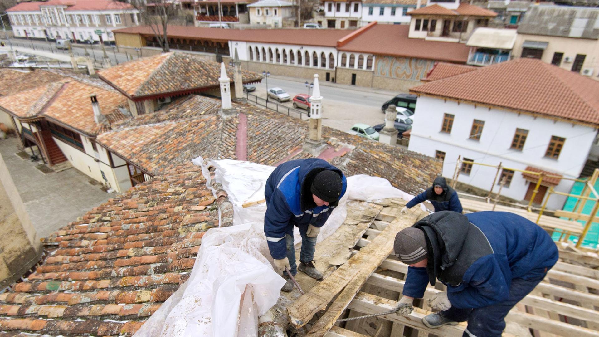 Handwerker reparieren das Dach des Khanpalasts in Bachtschyssaraj auf der Krim im Februar 2017. Handwerker reparieren das Dach des Khanpalasts in Bachtschyssaraj auf der Krim im Februar 2017.