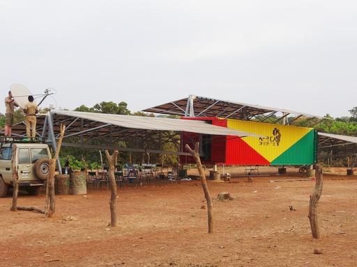 Ein Solartainer, mit dem Strom aus Sonnenenergie gewonnen wird, steht in einem Dorf.