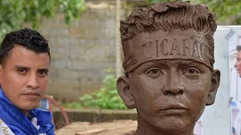 Büste eines Kindes mit Nicaraguabanner am Kopf und Bildhauer