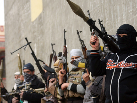 Bewaffnete Terroristen richten Maschinengewehre in die Höhe